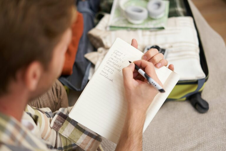 Close up portrait of man going through check-list, packing for holiday, looking at items he wants