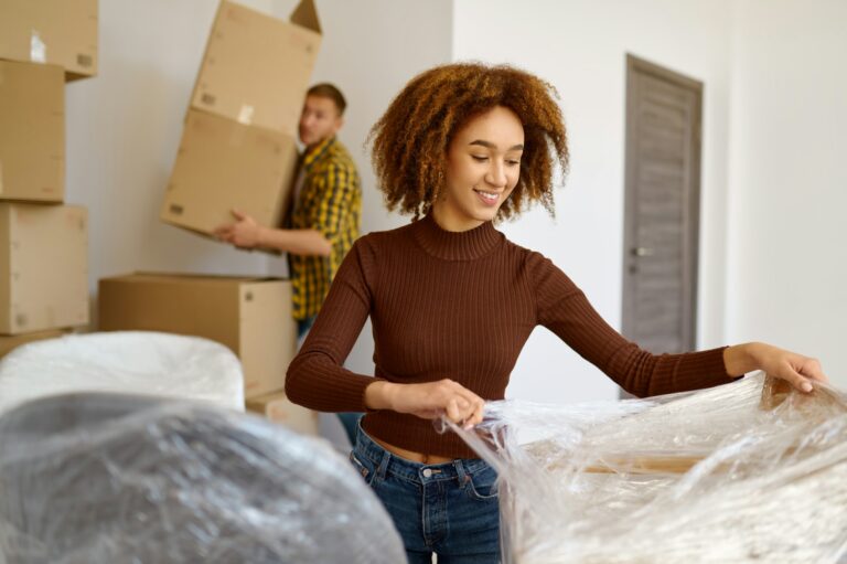 Couple packing box moving in new home